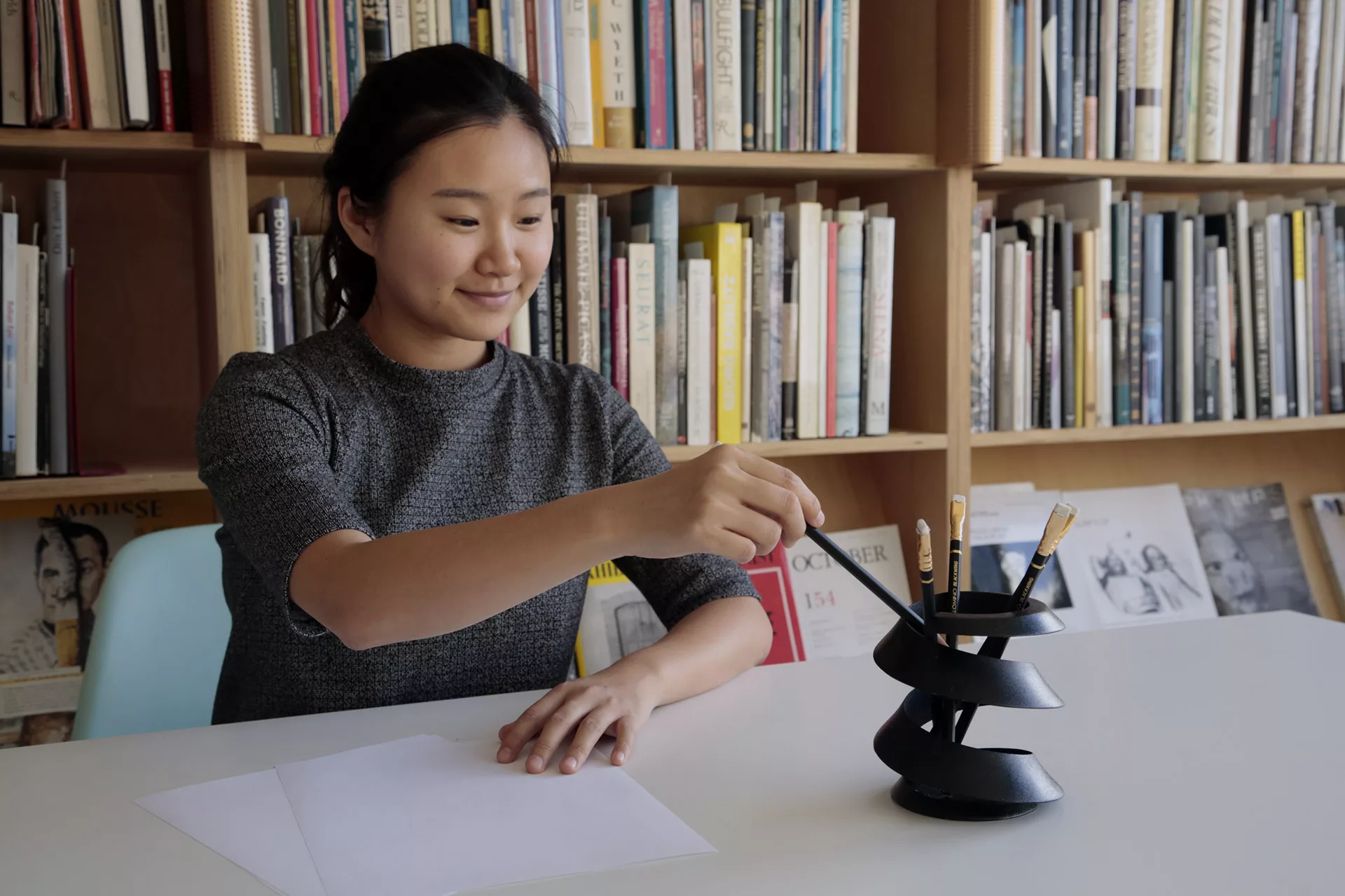 A woman hand lifting up a pencil from the Curvas.