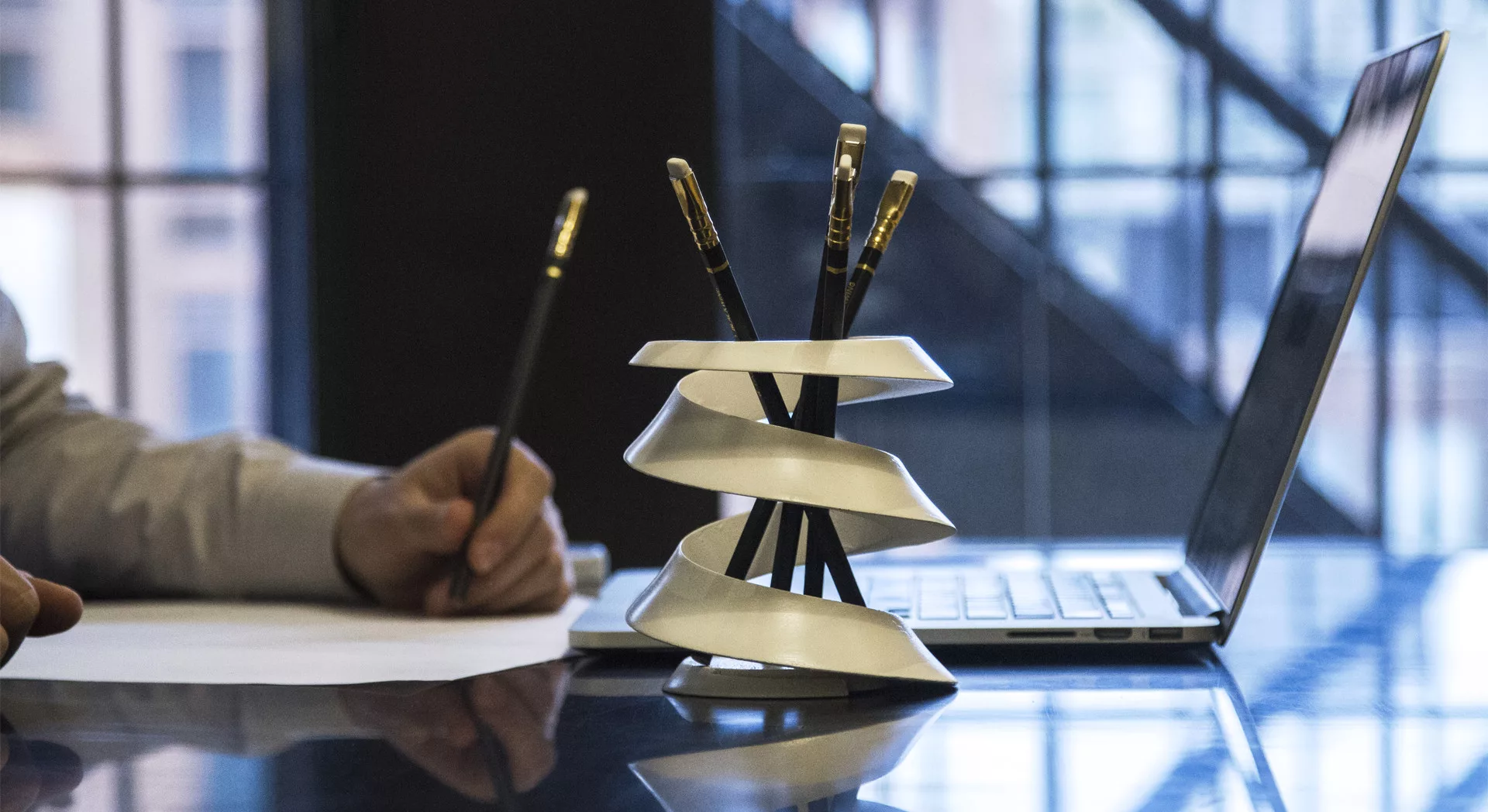 A curvas on a kitchen table, with a human working in the background.