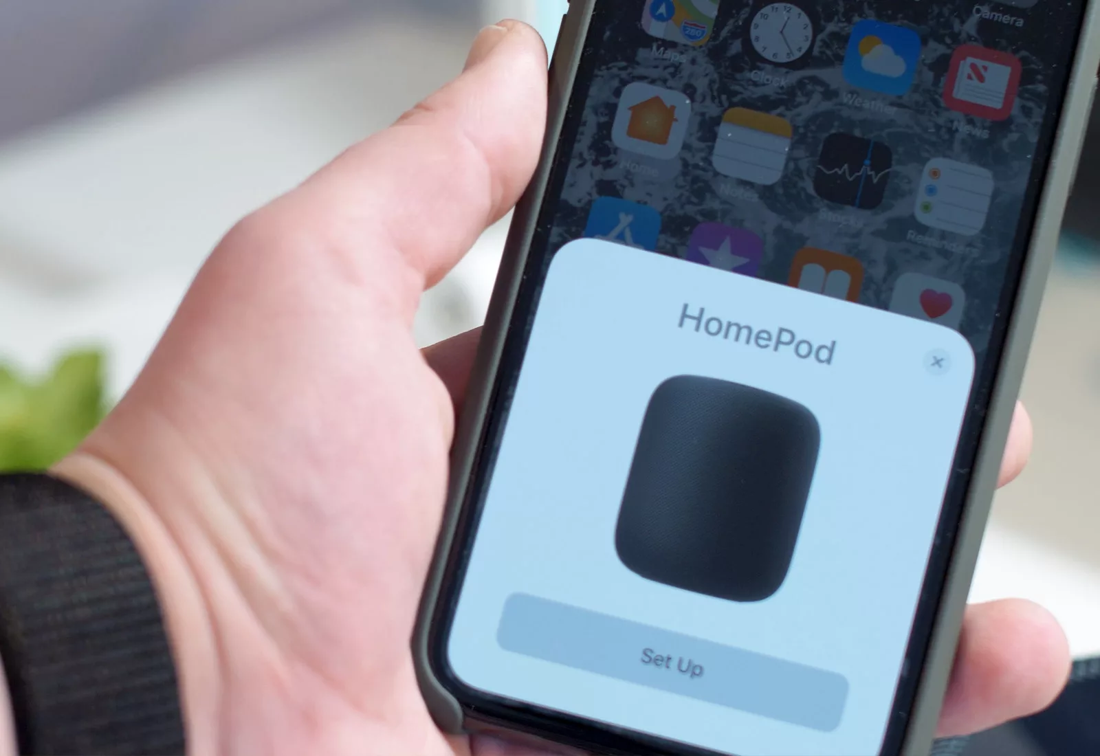 A person holding an iPhone prompting them to setup a HomePod
