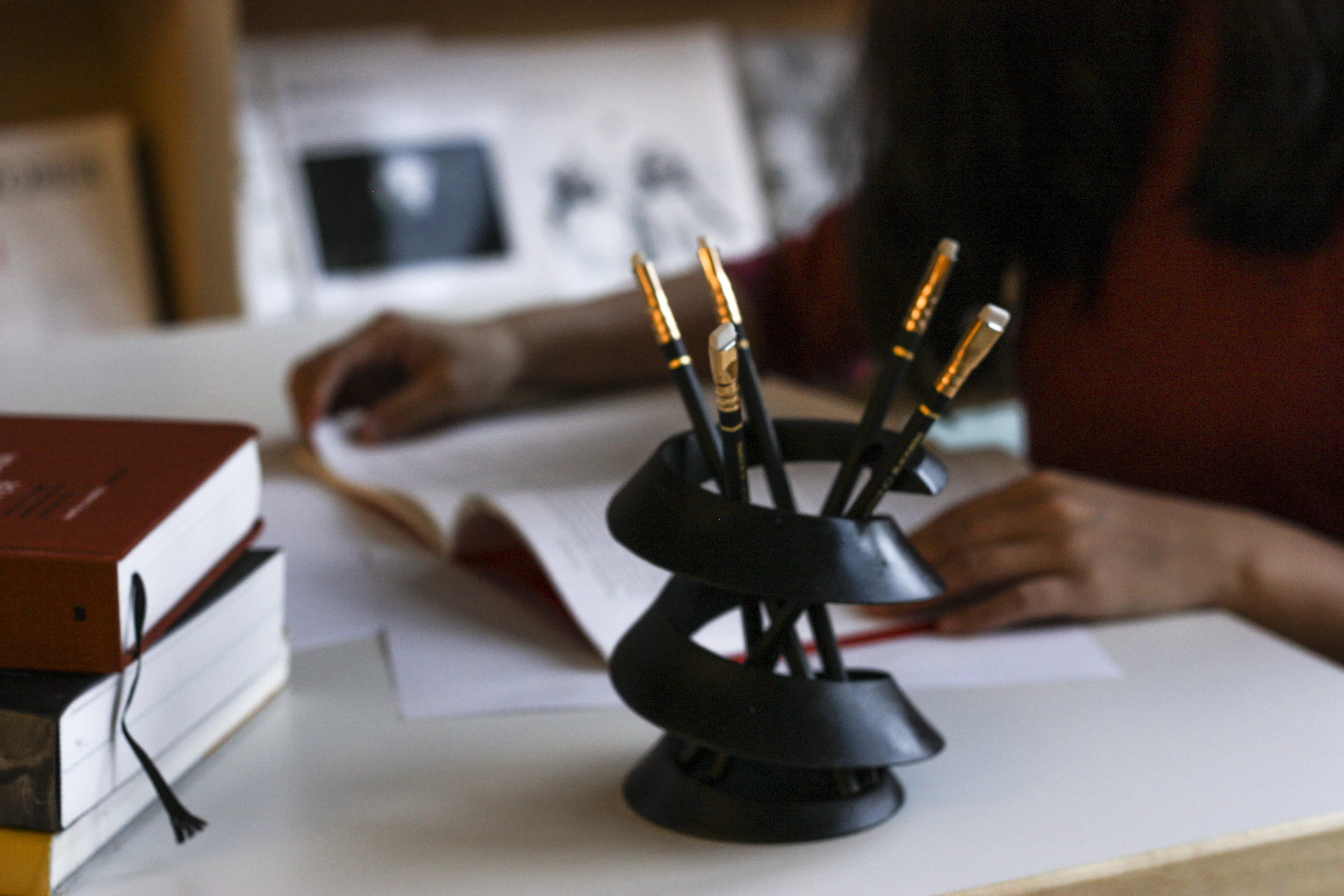 A curvas on a table, with a human working in the background.