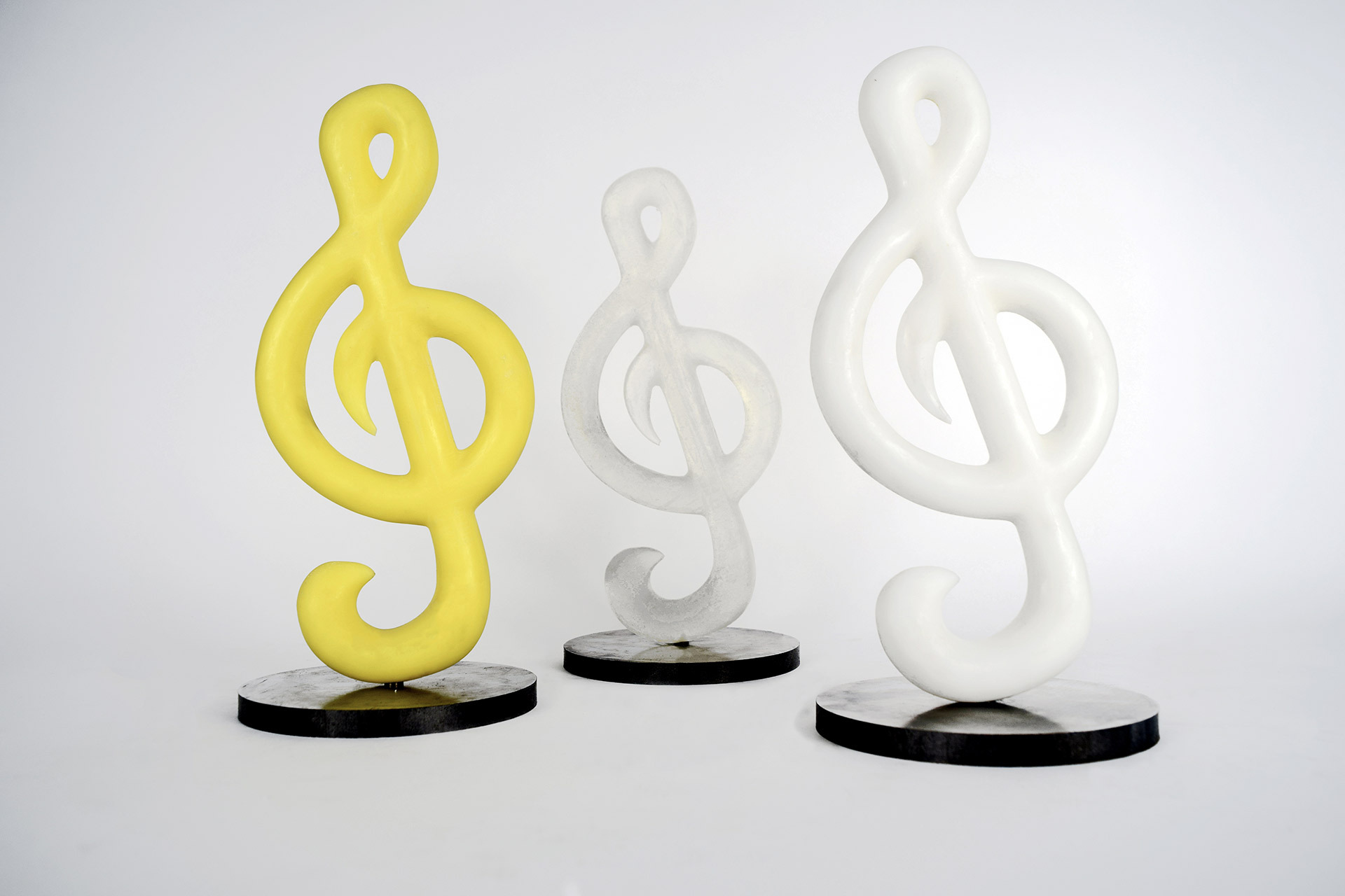 Samples of the Sol Stand in Yellow, Clear and White on a white background.