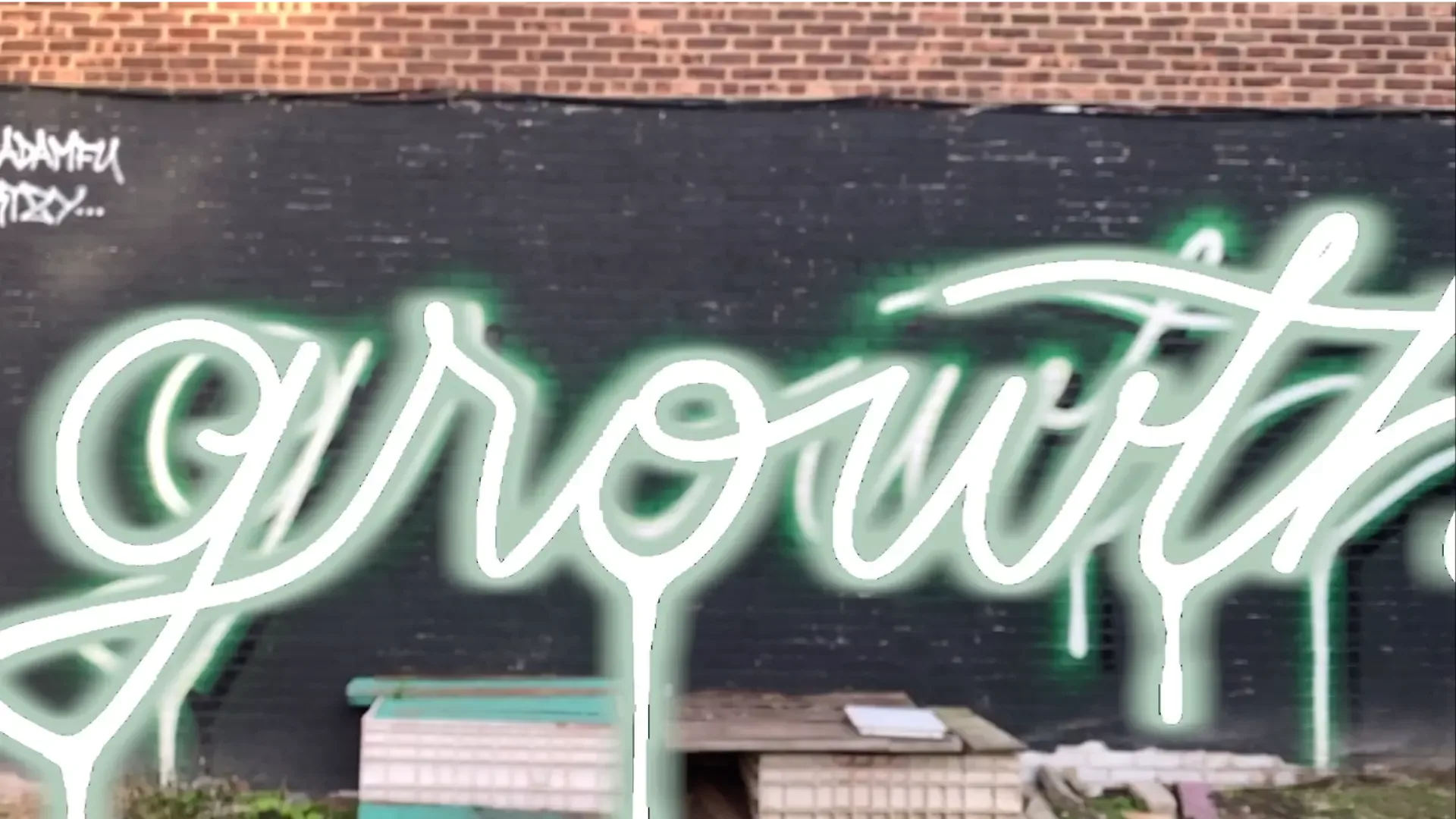 A graffiti with of the word "Growth" with an augmented reality 3D model overlayed over it;. The 3D model makes use of post-processing techniques to become illuminated with green neon glow.